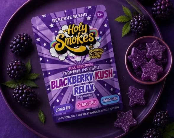 An overhead flat-lay of the Blackberry Kush pouch on a purple plate, with a small bowl of purple star gummies and loose blackberries around it.