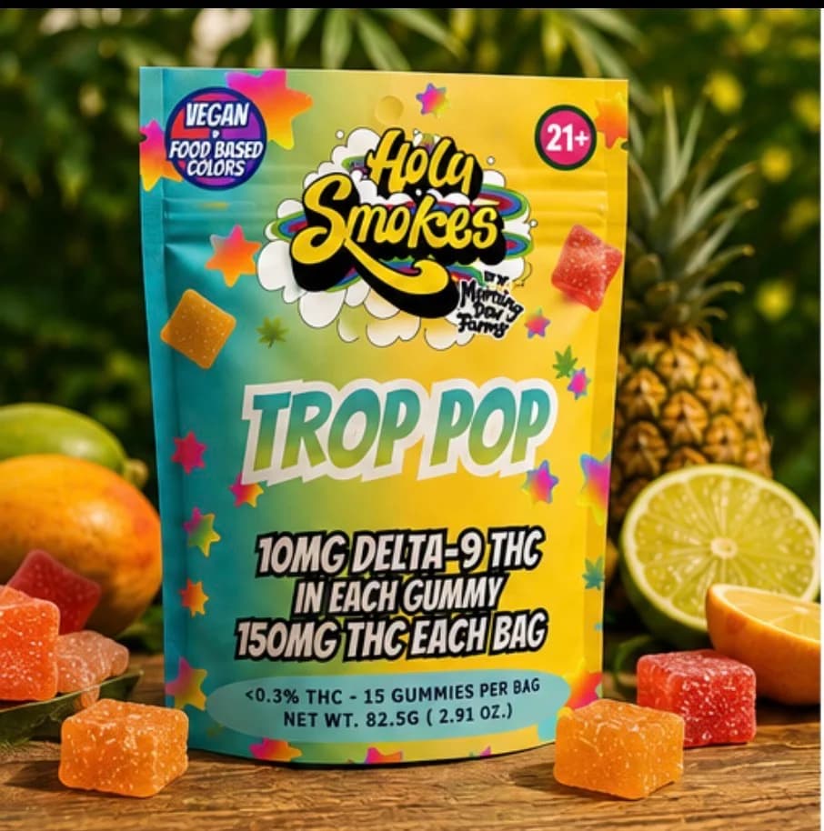 The yellow Holy Smokes Trop Pop pouch with orange and red sugared gummies, pineapple, lime and tropical fruit around it.